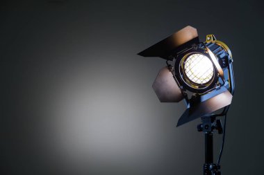Floodlight with halogen lamp and Fresnel lens on a gray background. Lighting equipment for shooting. Filming and photographing in the interior clipart