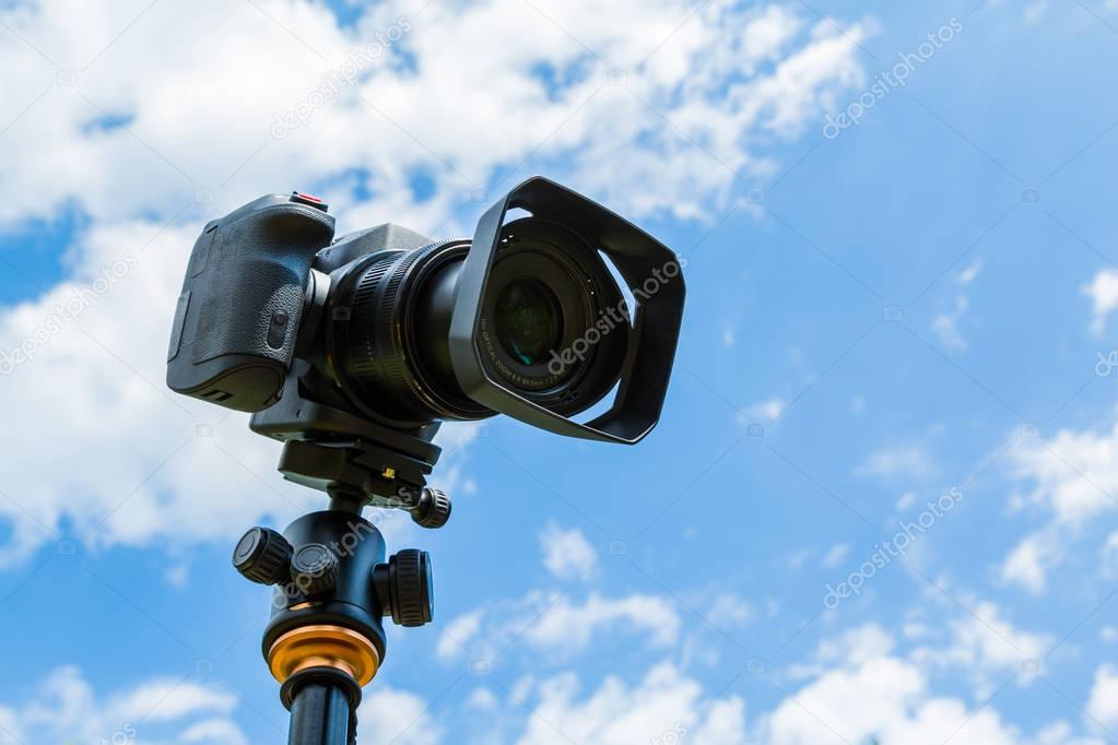 Digital camera closeup on a background of sky and clouds. Shooting on location and nature.
