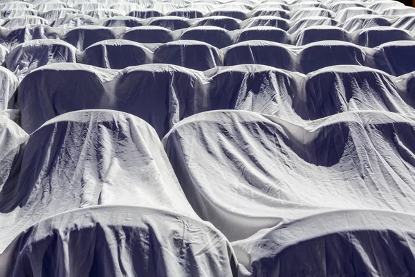 Chairs in the auditorium, covered with a white cloth to protect from dust and dirt — Stock Photo, Image