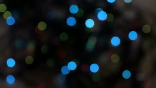 Luces de colores intermitentes en un desenfoque. El efecto bokeh. Luces eléctricas del árbol de Navidad. Clip de vídeo 4k — Vídeos de Stock