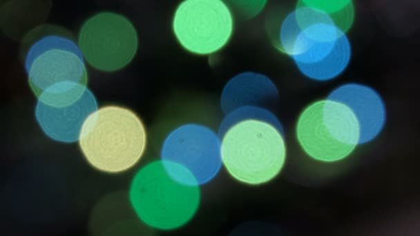 Luces de colores intermitentes en un desenfoque. El efecto bokeh. Luces eléctricas del árbol de Navidad. Clip de vídeo 4k — Vídeo de stock