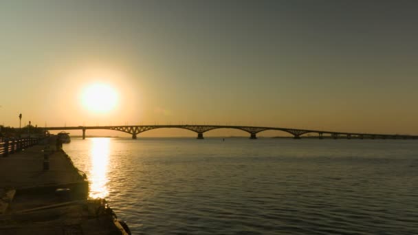 Ανατολή του ηλίου πάνω από μια γέφυρα του δρόμου κατά μήκος του ποταμού Βόλγα, Ρωσία. Η γέφυρα μεταξύ των πόλεων της Saratov και Ένγκελς. Το πρωί το καλοκαίρι. Βίντεο κλιπ 4k — Αρχείο Βίντεο