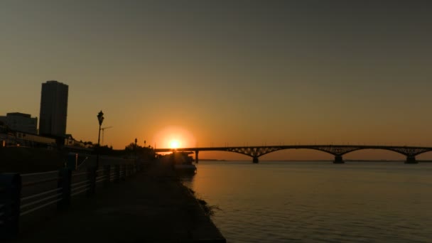 Nascer do sol sobre uma ponte rodoviária através do rio Volga, Rússia. A ponte entre as cidades de Saratov e Engels. Manhã de verão. Desfasamento temporal. Filmagem clip 4k — Vídeo de Stock