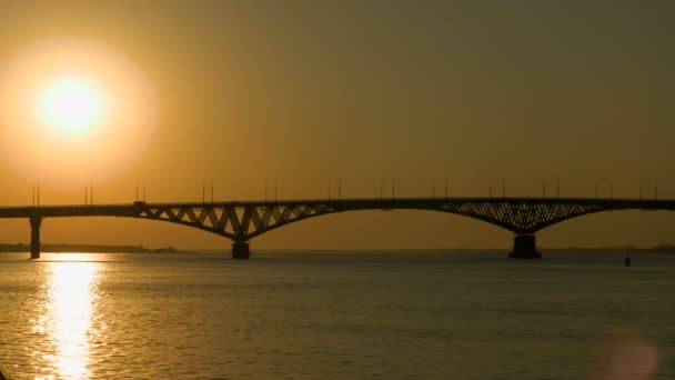 Ανατολή του ηλίου πάνω από μια γέφυρα του δρόμου κατά μήκος του ποταμού Βόλγα, Ρωσία. Η γέφυρα μεταξύ των πόλεων της Saratov και Ένγκελς. Το πρωί το καλοκαίρι. Βίντεο κλιπ 4k — Αρχείο Βίντεο