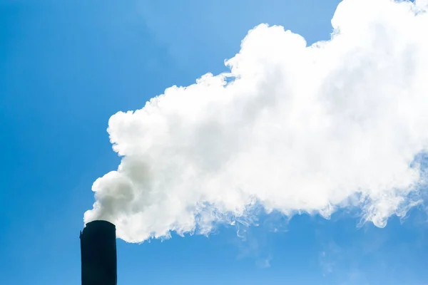 Bílý kouř z komína vychází na pozadí modré oblohy. Znečištění ovzduší a životní prostředí. Skleníkový efekt. Ekologická katastrofa — Stock fotografie