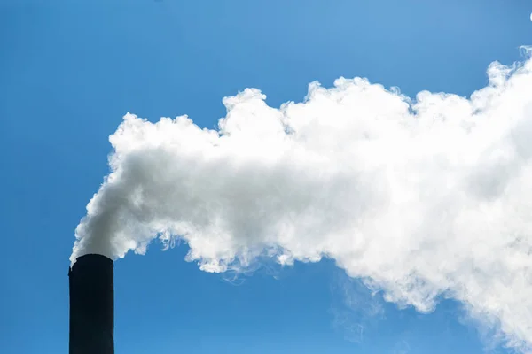 Bílý kouř z komína vychází na pozadí modré oblohy. Znečištění ovzduší a životní prostředí. Skleníkový efekt. Ekologická katastrofa — Stock fotografie