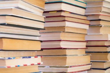 Renkli kapaklı kitap yığını. Kitaplık veya kitapçı. Kitap veya ders kitapları. Eğitim ve okuma