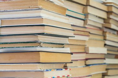 Renkli kapaklı kitap yığını. Kitaplık veya kitapçı. Kitap veya ders kitapları. Eğitim ve okuma