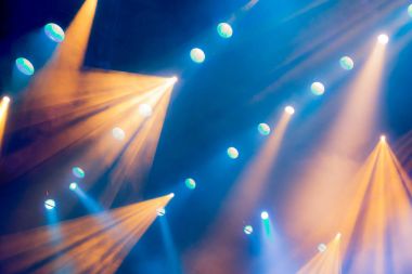 Aydınlatma donanımları Sahne Alanı'nda tiyatro performans sırasında. Duman ile gündeme gelen ışık ışınları. Mavi ve sarı ışık ışınları