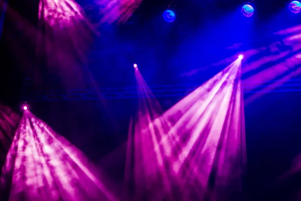 Rayos azules y púrpuras desde el centro de atención a través del humo en el teatro o sala de conciertos. Equipo de iluminación para una actuación o espectáculo —  Fotos de Stock