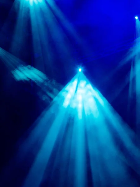 Raios de luz azul dos holofotes através da fumaça no teatro ou sala de concertos. Equipamento de iluminação para um desempenho ou show — Fotografia de Stock