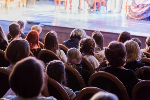 The audience in the theater watching a play. The audience in the hall: adults and children — Stock Photo, Image