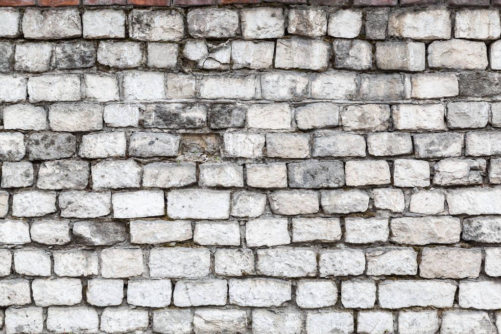 The old stone walls. The brick wall of the house. Grey textured background. Abstraction