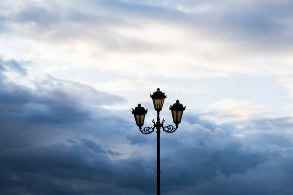 Lâmpada de rua contra o céu e as nuvens. Silhueta — Fotografia de Stock