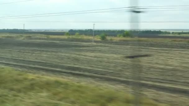 Filmando desde la ventana de un tren en movimiento. Paisaje otoñal ruso: campos, bosques, plantación, cielo — Vídeos de Stock