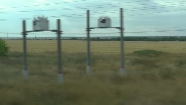 Natáčení z okna jedoucího vlaku. Ruské podzimní krajina: pole, lesy, výsadba, obloha — Stock video