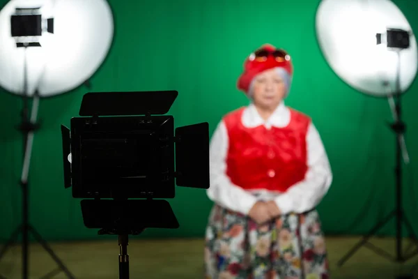 Atriz em traje teatral em um estúdio de televisão. Tela verde e chave chroma. Equipamento de iluminação e equipamento de filmagem — Fotografia de Stock