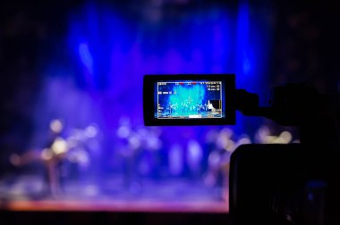 Aula gösterisinden filme. Belgili tanımlık camcorder üzerinde LCD vizör. Tiyatro performans. Oyuncular sahnede. Odak arka plan. Focus ön planda.
