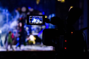 Aula gösterisinden filme. Belgili tanımlık camcorder üzerinde LCD vizör. Tiyatro performans. Oyuncular sahnede. Odak arka plan. Focus ön planda.