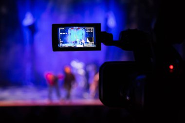 Aula gösterisinden filme. Belgili tanımlık camcorder üzerinde LCD vizör. Tiyatro performans. Oyuncular sahnede. Odak arka plan. Focus ön planda.
