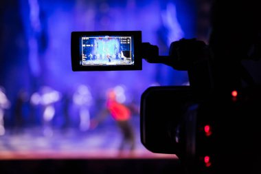Aula gösterisinden filme. Belgili tanımlık camcorder üzerinde LCD vizör. Tiyatro performans. Oyuncular sahnede. Odak arka plan. Focus ön planda.