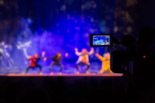 Aula gösterisinden filme. Belgili tanımlık camcorder üzerinde LCD vizör. Tiyatro performans. Oyuncular sahnede. Odak arka plan. Focus ön planda.