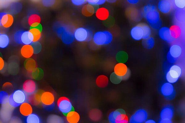 Christmas abstract blurred background. Multi-colored lights. Unfocused image. Christmas tree garland in a blur.