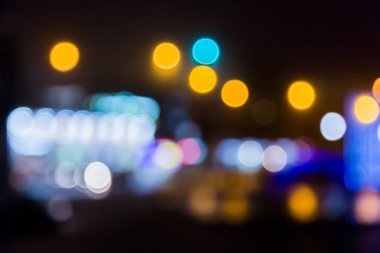 Bulanık arka plan. Bulanık sokak ışıkları. Akşam veya gece şehir. Işık vitrinler ve arabalar.