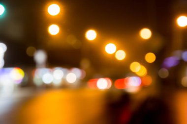 Bulanık arka plan. Bulanık sokak ışıkları. Akşam veya gece şehir. Işık vitrinler ve arabalar.