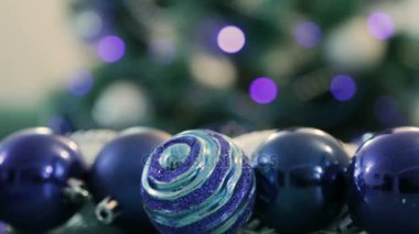 Mavi ışıklar ile Noel ağacı dekore edilmiştir. Noel topları ön planda. Bir Noel ağacı içinde belgili tanımlık geçmiş bulanık görüntü.