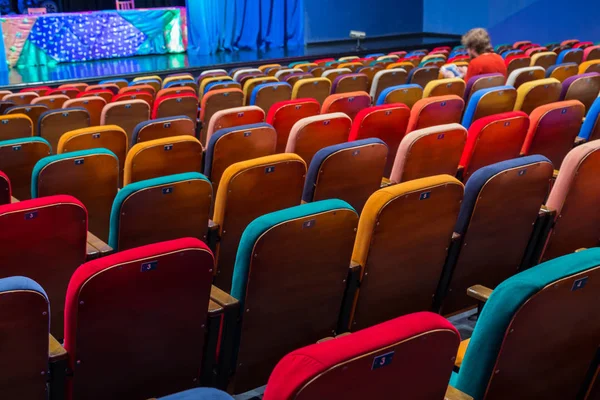 剧院的礼堂多彩多姿的观众的椅子 观众中的一个人 — 图库照片