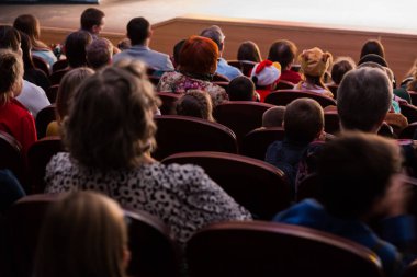 İnsanlar, bir çocuk programı izlerken seyirciler çocuklu anne. Sattı. Arkadan çekim.