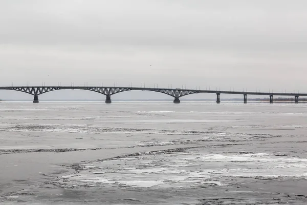 サラトフの都市とエンゲルスのヴォルガ川を渡る橋 川を氷します ロシア — ストック写真