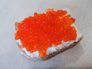 Kırmızı havyar ile sandviç. Beyaz ekmek tereyağı ile. Deniz ürünleri lezzetleri.