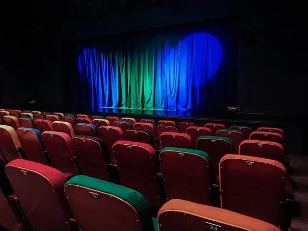 劇場の講堂 ステージ上のブルー グリーン カーテン 色とりどりのスペクテーターの椅子 照明器具 — ストック写真