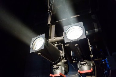 Bir tiyatro ya da konser salonunun aydınlatma donanımları Sahne Alanı'nda. Spot ışık ışınları. Halojen ve led ampulleri. Lens Aydınlatma.