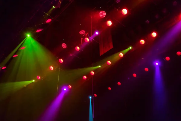 Lighting equipment on the stage of a theatre or concert hall. The rays of light from spotlights. Halogen and led light bulbs. Lens lighting.