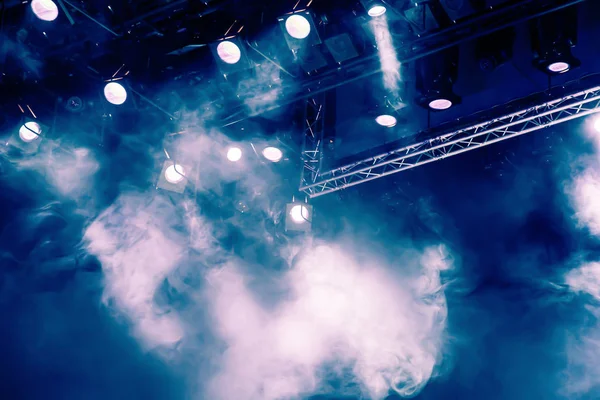Blue light rays from the spotlight through the smoke at the theater or concert hall. Lighting equipment for a performance or show