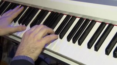 Müzisyen bir dijital piyano çalıyor. Piyanist elleri. Bir sentezleyici veya elektronik piyano.