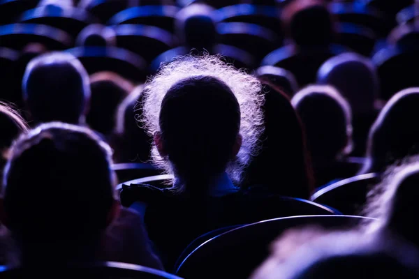 Spectators in the theater or in the cinema. Children and adults. Full house.