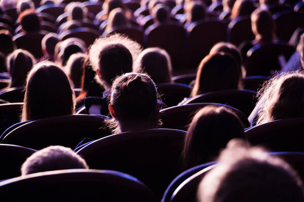 Spectators in the theater or in the cinema. Children and adults. Full house.