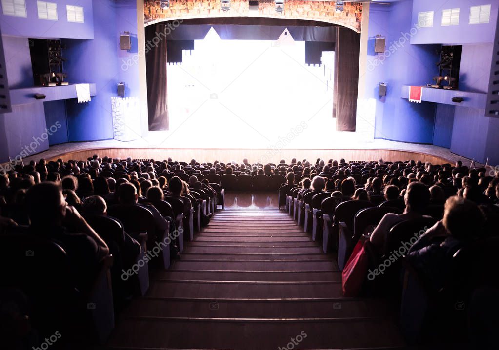 Spectators in the theater or in the cinema. Children and adults. Full house.