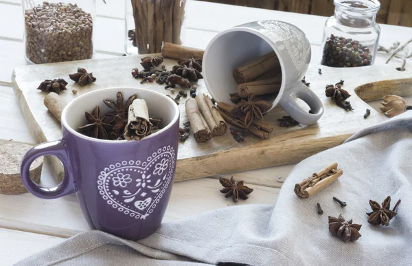 Bekers met anijs, kaneel, kruidnagel en peper op een oud houten tafel. — Stockfoto