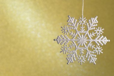 Parıldayan elmas sarı bir arka plan üzerinde güzel kar taneleri.