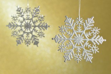 Parıldayan elmas sarı bir arka plan üzerinde güzel kar taneleri.