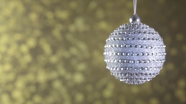 Zilveren kerst bal ruit op een gouden fonkelende achtergrond. — Stockvideo