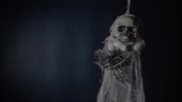 Esqueleto terrível pendurado em um fundo azul escuro . — Vídeo de Stock