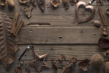 Çerçeve tasarımcı kuru yapraklar ve bronz Noel oyuncaklar eski ahşap bir masa üzerinde.