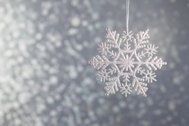 Gümüş arka plan bokeh üzerinde kar taneleri pırıl pırıl gümüş elmas.