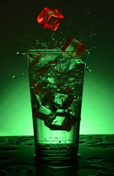 Schöner Splash Cocktail mit Eis. kariertes facettiertes Glas mit einem Cocktail. — Stockfoto